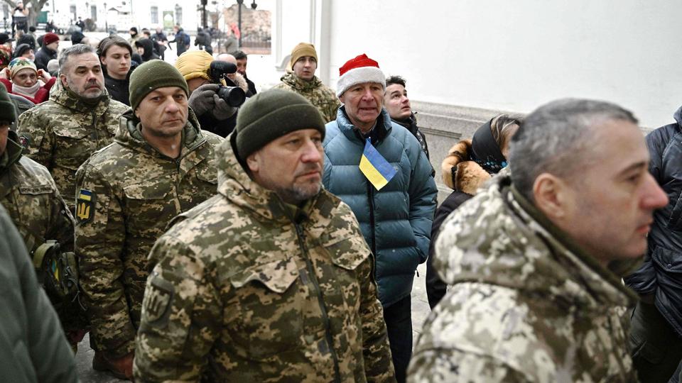 Ukrainske soldater står lørdag i kø foran Kyivs kloster Petjerska for at deltage i den ortodokse julemesse. Rusland siger, det holder en to dage lang våbenhvile i forbindelse med den ortodokse jul. Men den ensidige våbenhvile, der løber frem til midnat lørdag, er blevet brudt flere gange. <i>Genya Savilov/Ritzau Scanpix</i>