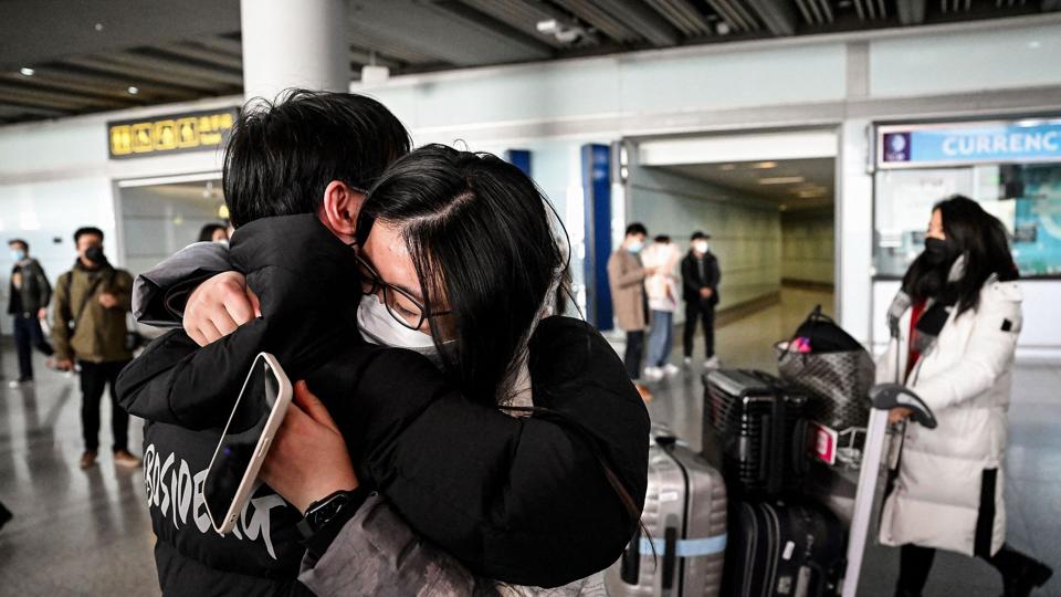 Et par krammer i ankomsthallen i Capital International Airport i Beijing søndag, hvor Kina åbnede sine grænser i kølvandet på coronapandemien. <i>Noel Celis/Ritzau Scanpix</i>