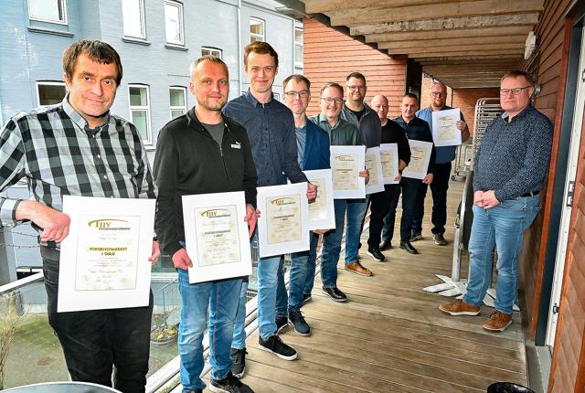 De ni chauffører får guld eller sølv-diplom af formand for Thy Vognmandsforening Mark Kristensen (th). Se navnene i artiklen.