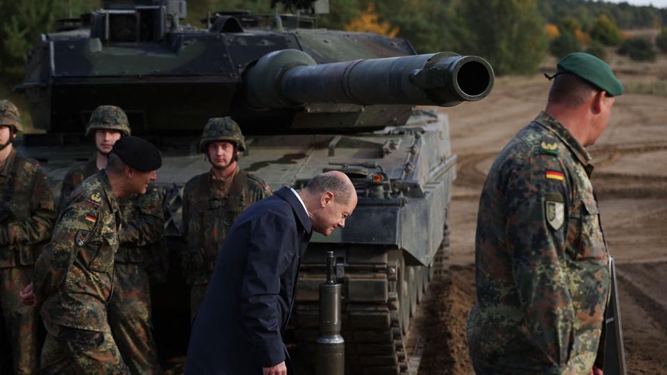 Der er pres på den tyske forbundskansler, Olaf Scholz (i midten), for at tillade, at de tyskproducerede kampvogne af typen Leopard 2 - som han inspicerer her - bliver sendt til Ukraine. Scholz har tøvet og sagt, at han skal konferere med de allierede i Nato. (Arkivfoto) <i>Ronny Hartmann/Ritzau Scanpix</i>