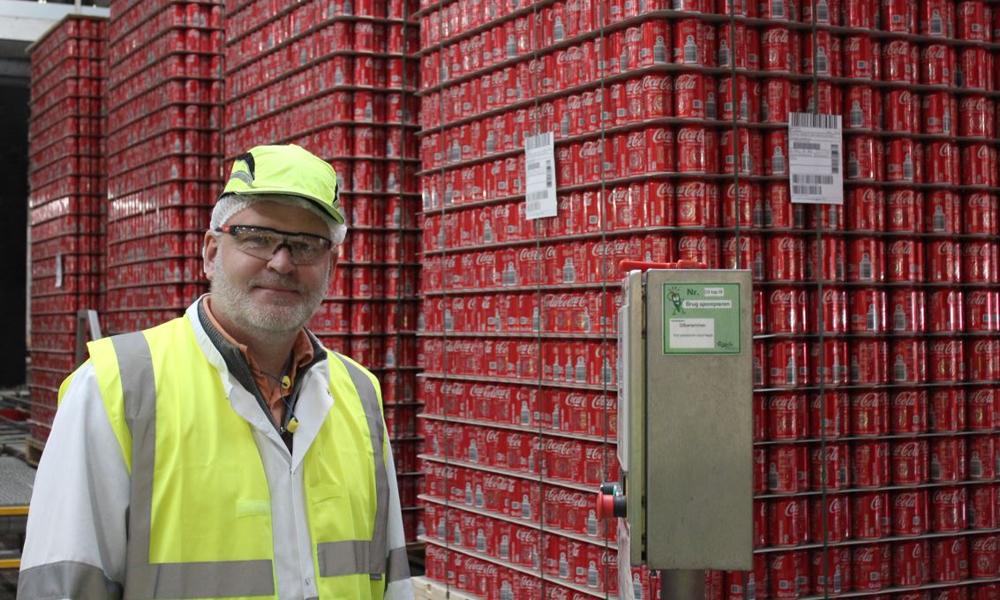 Håkan Stevén ved linjen, hvor enorme mængder af tomme Coca-Cola-dåser triller ind klar til at blive fyldt op. Håkan Stevén ved linjen, hvor enorme mængder af tomme Coca-Cola-dåser triller ind klar til at blive fyldt op.