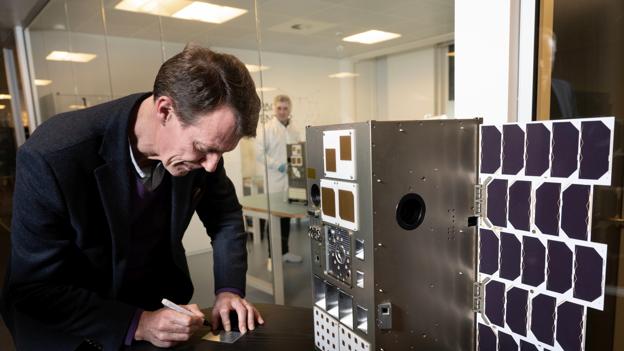Her underskrev prinsen blandt andet en lille plakette, der skal sendes op sammen med satellitten. <i>Foto: Lars Horn / Baghuset</i>