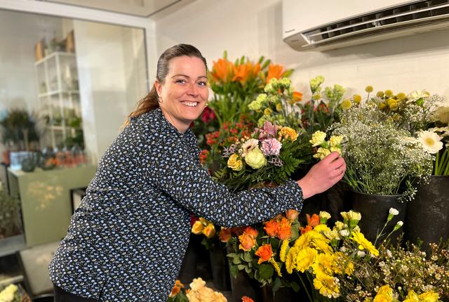 Lene Dahl Haldrup omgivet af det bedste hun ved, farverige blomster.