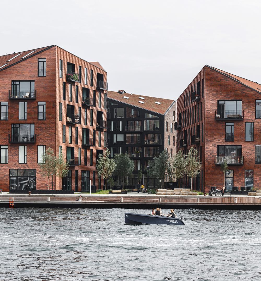 Krøyers Plads i København med den dybe røde beklædningstegl på både de foldede tage og facaden betegnes en moderne fortolkning af de industrielle og historiske pakhuse, som Krøyer Plads er omringet af. Byggeriet er opført med Egernsund Wienerbergers beklædningsteglog er tegnet af Vilhelm Lauritzen Arkitekter, Cobe og GHB Landskabsarkitekter. Krøyers Plads i København med den dybe røde beklædningstegl på både de foldede tage og facaden betegnes en moderne fortolkning af de industrielle og historiske pakhuse, som Krøyer Plads er omringet af. Byggeriet er opført med Egernsund Wienerbergers beklædningsteglog er tegnet af Vilhelm Lauritzen Arkitekter, Cobe og GHB Landskabsarkitekter.