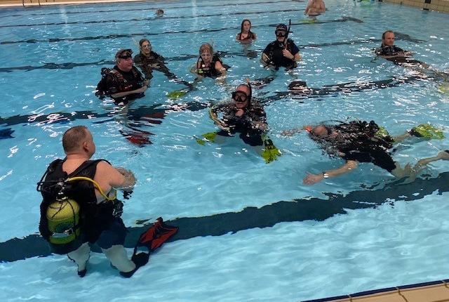 30 medlemmer af Pandrup Dykkerklub var mødt op for at deltage i jubilæumsarrangementet, hvor lyset i svømmehallen blev slukket.