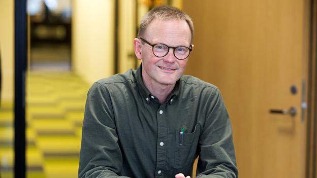 Direktøren er godt tilfreds med, at sparekassen red rentestormen af. Det ternede tæppe i skarpe kulører samler den gamle og nye del af sparekassebygningen i Vestergade og de 27 medarbejdere. <i>Foto: Bo Lehm</i>