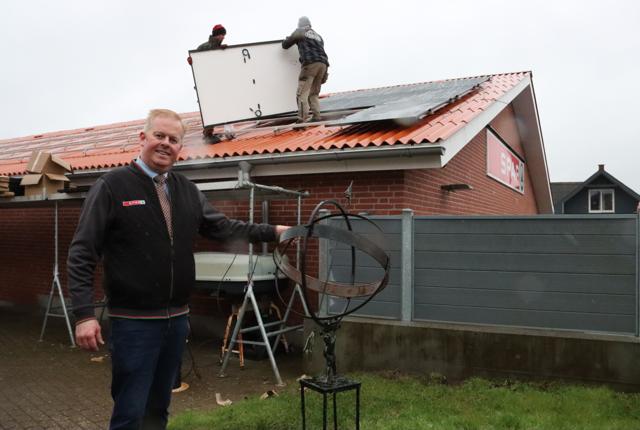 Købmand Lars Jensen investerer i solceller for at spare på elregningen. De første af 196 paneler er ved at blive lagt på taget.