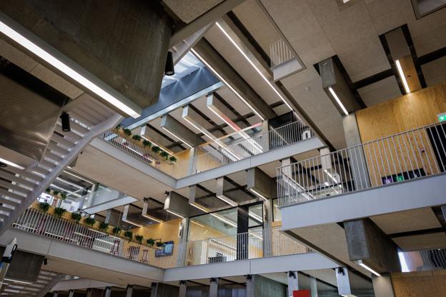 AAU Innovate har det arkitektoniske princip om ærlighed i konstruktionen til fælles med de ældre universitetsbygninger. Betonkonstruktionerne er fuldt synlige i bygningens interiør og tydeligt fyldt ud med ikke-bærende træpaneler. <i>Foto: Henrik Bo</i>