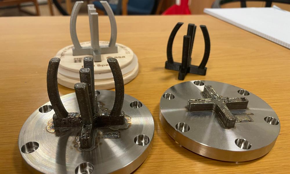 DTU Space har designat de fyra element som en specialbyggd 3D-metallskrivare ska försöka återskapa i rymden. Därefter måste de fyra rymdavtrycken föras tillbaka till jorden och jämföras med de fyra tryckta i jordens atmosfär.  DTU Space har designat de fyra element som en specialbyggd 3D-metallskrivare ska försöka återskapa i rymden. Därefter måste de fyra rymdavtrycken föras tillbaka till jorden och jämföras med de fyra tryckta i jordens atmosfär.