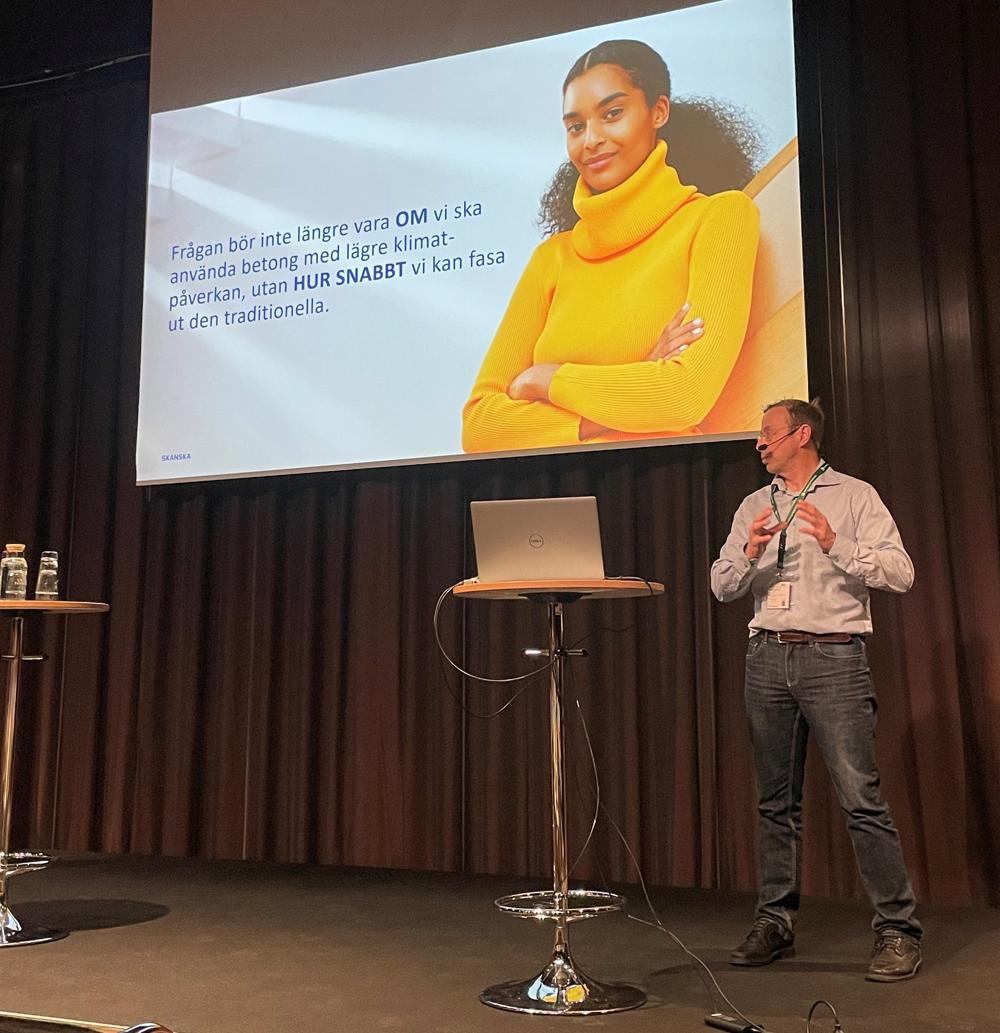 ”Frågan är inte längre OM vi ska använda betong med lägre klimatpåverkan, utan HUR SNABBT vi kan fasa ut den traditionella”, står det på storbild när Johan Hedman talar under Byggmaterialdagen. ”Frågan är inte längre OM vi ska använda betong med lägre klimatpåverkan, utan HUR SNABBT vi kan fasa ut den traditionella”, står det på storbild när Johan Hedman talar under Byggmaterialdagen.