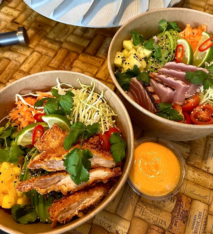Poke bowls, som her ses med kylling og tun, med friske og marinerede grøntsager på en skål sushi-ris med en smagfuld dressing.