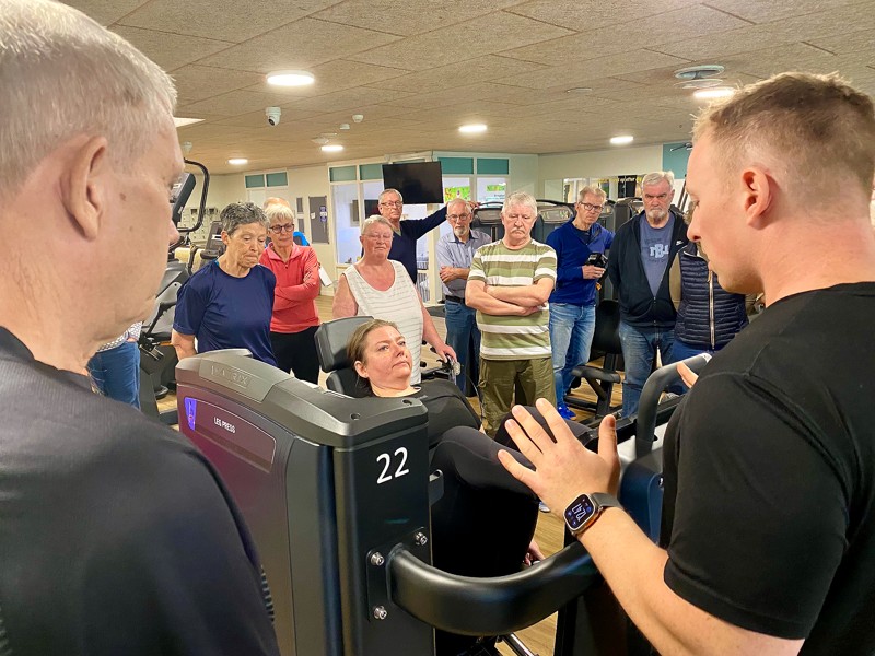 Styrketræning er vigtig for alle og ikke mindst for ældre. Her viser Mathias Vedsø Kristiansen (yderst til højre) hvordan en af motionsmaskinerne skal bruges.