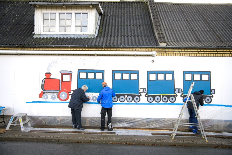 Børn og borgere i Hørdum har malet et futtog over for stationen i Hørdum, på en lang mur i den bygning, hvor der tidligere var kiosk. Foto: Bo Lehm