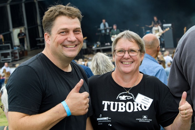 Store smil hos festivalledelsen, Nina Andersen og Johnny Markussen, mens Hjalmar spiller i baggrunden.