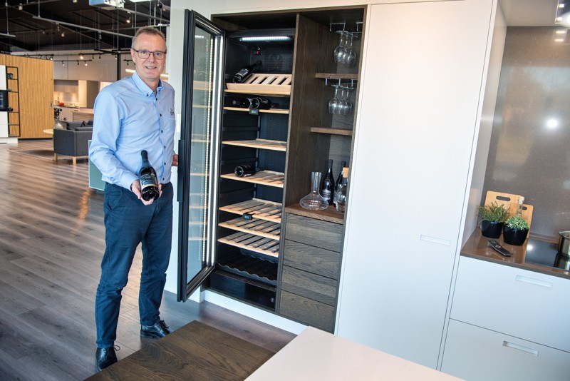 Indretningskonsulent Lasse Høyer fra Svane Køkkenet ved et populært sommelier-skab. Prisen for skabet ligger i omegnen af 10.000 kroner. Flot ser det ud, og så har vinen den rette temperatur, når den skal i glasset. Foto: Bente Poder
