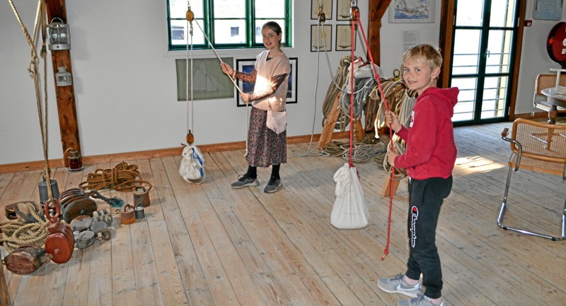 Der er flere forskellige aktiviteter på museet for børn. De kan blandt andet lære at binde knob og læse signalflag - eller som her: prøve kræfter med sandsække og mærke, hvordan sådanne sække kan gøre tunge ting lette. Foto: Nordjyske Museer