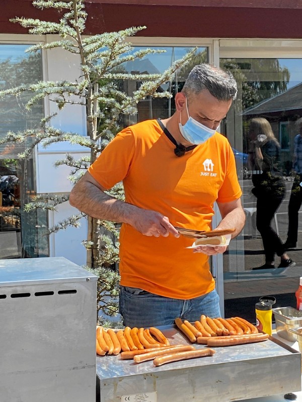 Mojtaba Daliri fra Pølsehuset i Hobro er godt i gang med at servere hotdogs hos botilbuddet Rørbæk Omsorgshjem. Privatfoto