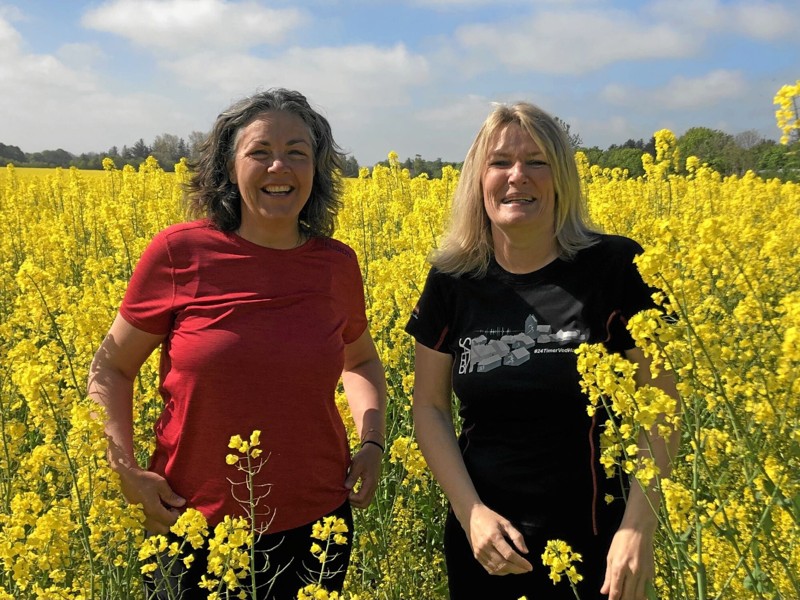 Om man er blå eller rød, så klæder en gul rapsmark både naturen, Mette Hardam og Birgit Stenbak Hansen. Foto: Lisa Farum Kristiansen