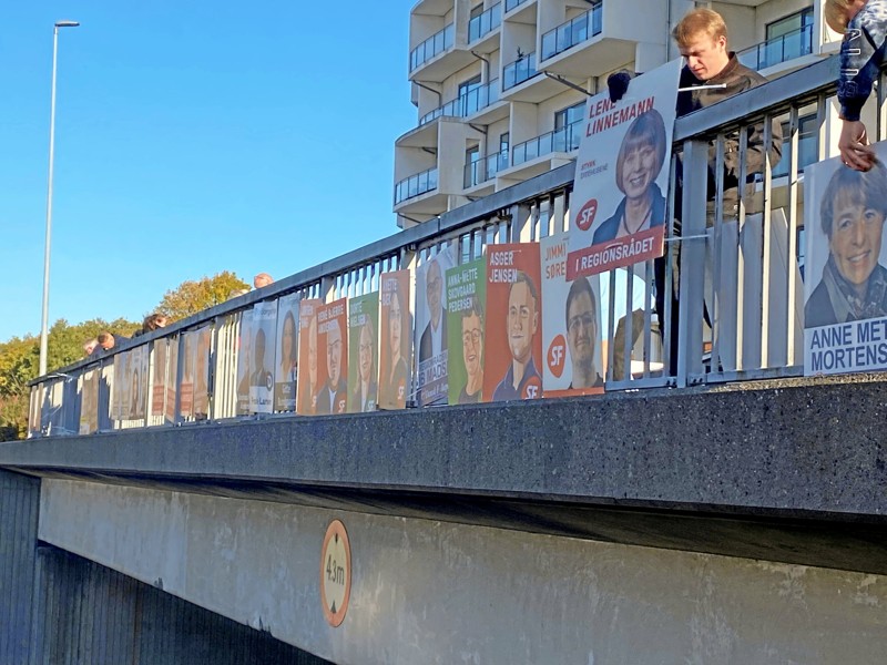 Så går det løs - klokken 12 blev broen over Frederikshavnsvej dækket med politiske valgplakater.