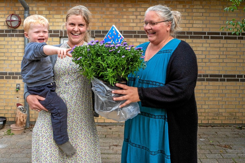 Børnehusets første vuggestuebarn August og hans mor Henriette kommer med blomster til lederen af Børnehuset Lillian Lyng Thørholm. Foto: Niels Helver