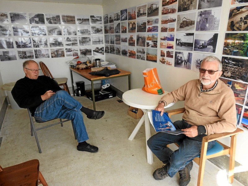 Her sidder Peter Mortensen og Helge Christensen i ladet, som er fyldt med gamle foto og ringbind fyldt med foto fra en svunden tid. Foto: Jens Brændgaard
