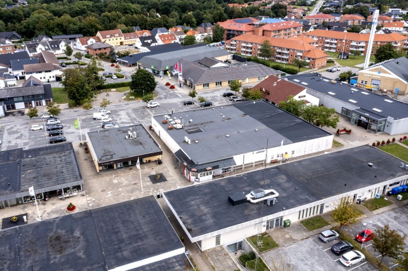 Nedrivningen af supermarkedet - der her ses i midten af billedet - forventes i slutningen af året eller alternativt i starten af 2023. Efterfølgende vil der komme grusbelægning på arealet, som kan anvendes til for eksempel midlertidig parkering - og senere vil der så komme mere konkrete planer for en fremtidig anvendelse af arealet. Nedrivningen giver eksempelvis mulighed for torvedannelse ved Hjallerup Centret. Foto: Torben Hansen