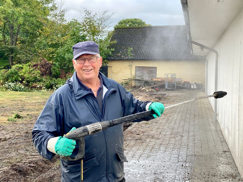 Poul Brander er i gang med at vaske en af murene på købmandsforretningen i Halvrimmen, så den kan blive klar til maling.