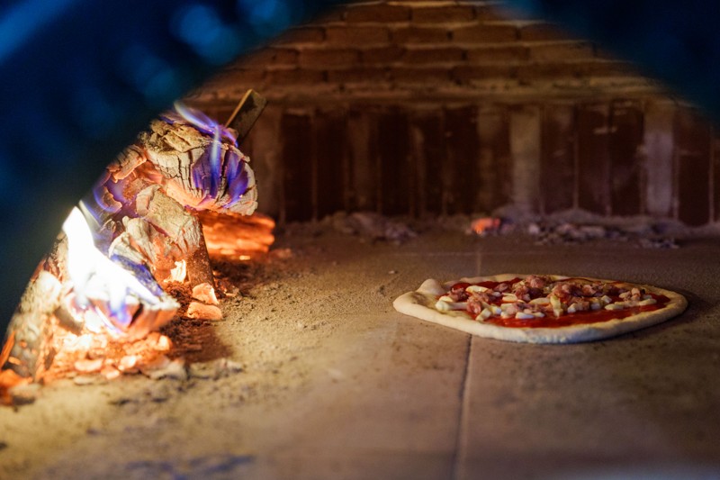 Pizzaerne bliver bagt her i den brændefyrede ovn, noget der er med til at give en helt ærlig smagsoplevelse.
