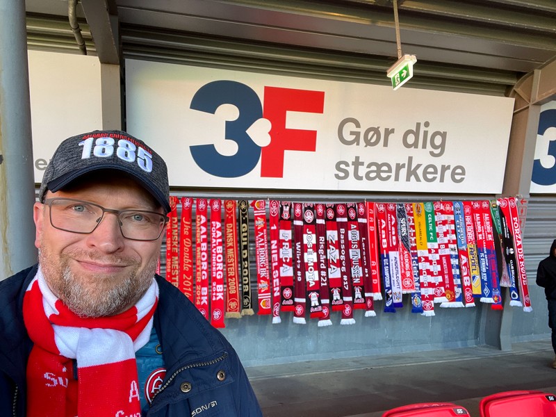 Lars Hvilsted foran et udpluk af halstørklæderne på 3F-tribunen på Aalborg Portland Park.