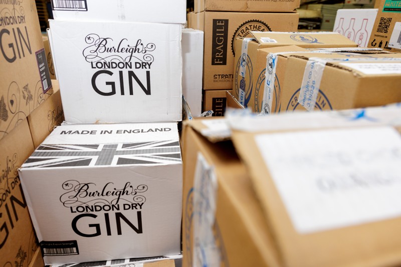 Kasser med gin fra Storbritannien står stablet på et lager i Hobro. 