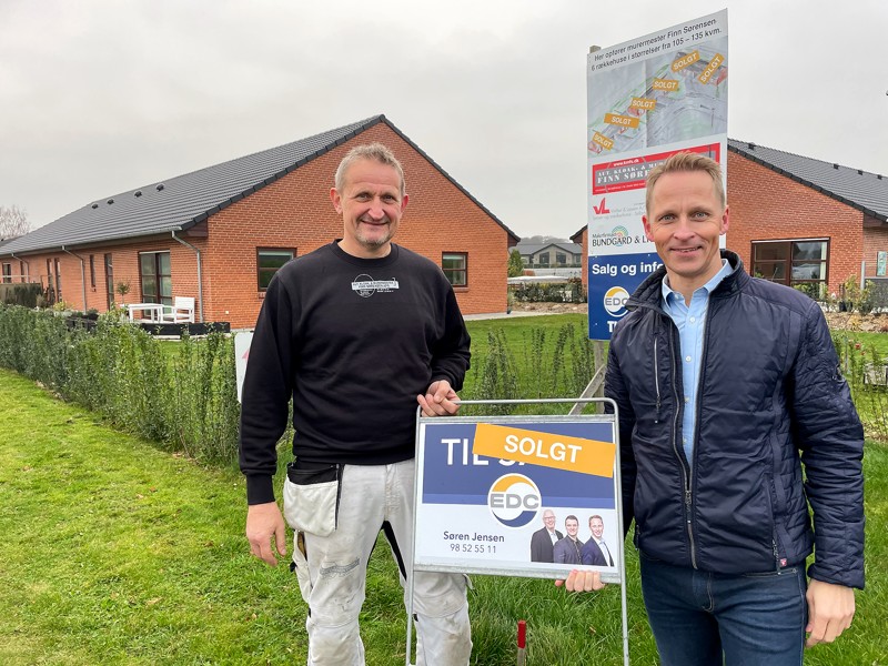 Finn Sørensen og Thomas Jensen ved skiltet, der viser at alle seks rækkehuse er solgt.