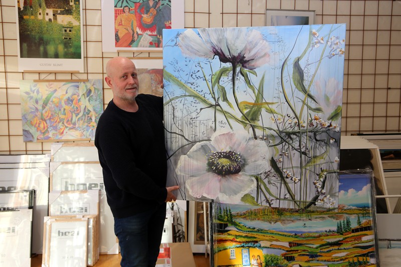 Lars Falk med et af Naja Duartes blomstermotiver. Bag billedet skimtes et Steen Karlsen-maleri.