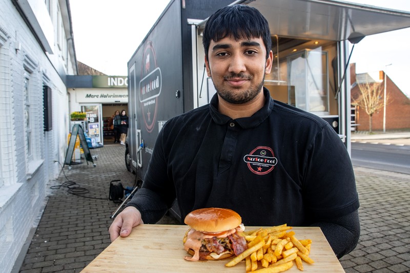 Noah Drejer viser søndagens hit i Halvrimmen. En frisklavet burger med ost og bacon og pommes frites, der er krydret med Nordsoes egne krydderier.