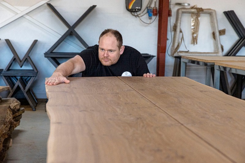Pladen på plankebordet er glat og fin, som den skal være, konstaterer David Nymand. De to planker, som bordet er lavet af, kommer fra samme træ, så det ser ud, som at de spejler sig i hinanden.