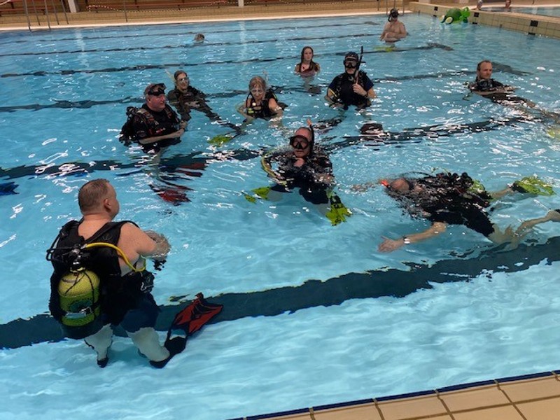 30 medlemmer af Pandrup Dykkerklub var mødt op for at deltage i jubilæumsarrangementet, hvor lyset i svømmehallen blev slukket.