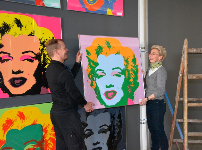 Peter Nygaard Christensen og Anne Rottbøll her nænsomt i gang med at hænge Marilyn Monroe's billeder op