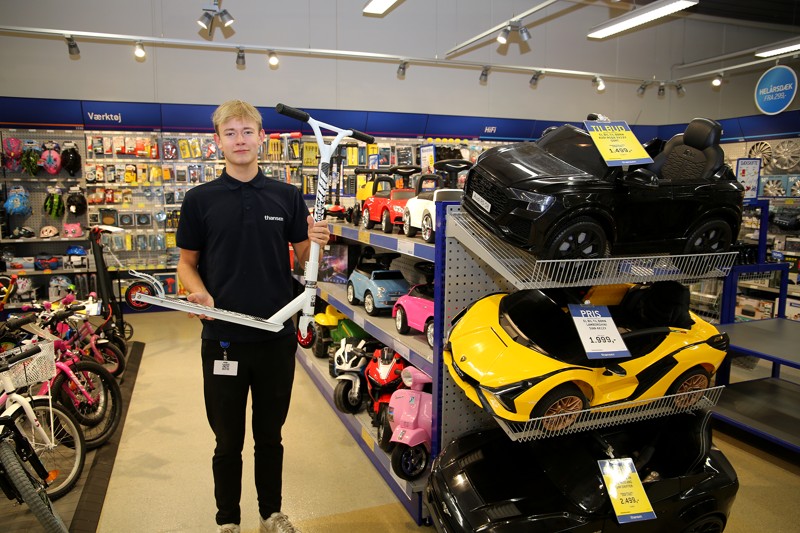 Butikselev Frederik Jønsson i den ny afdeling med løbehjul og legebiler.