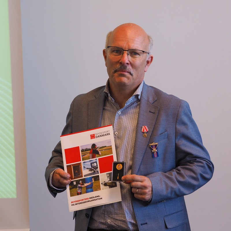 Nordjyske Lars Peter Høgh stopper som formand for DGI Skydning efter 10 år - og han hyldes samtidig med hele tre ærespriser fra samarbejdspartnere. Her ses han med Dansk Skytteunions Hæderstegn.