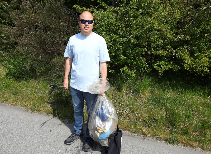 Mads Bastholm Nørgaard med en sæk plastaffald og en taske med glasaffald.